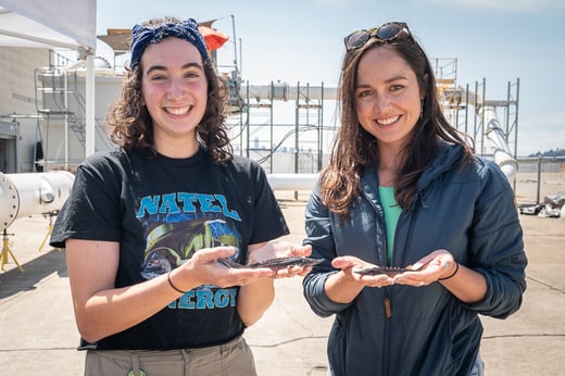 Simone Lassar and Sterling Watson hold juvenile white sturgeon during a fish passage study at Natel's in-house test facility.